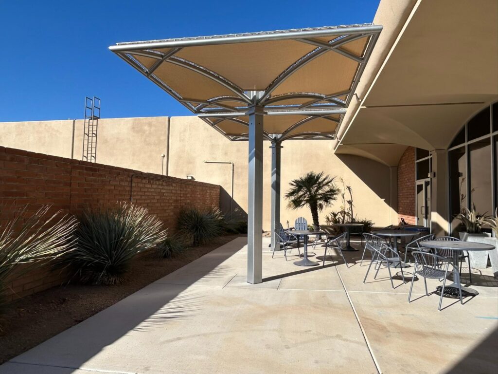 Steel umbrella shade structure covering patio space